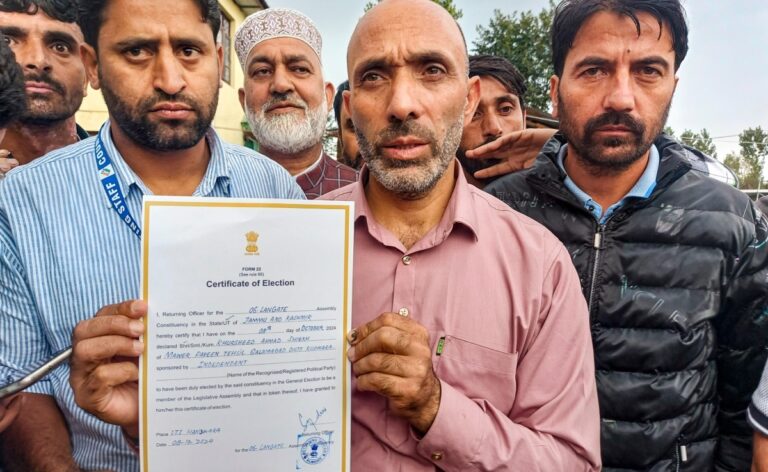 Khurshid Ahmed Sheikh showing the certificate of victory from Langate assembly seat.