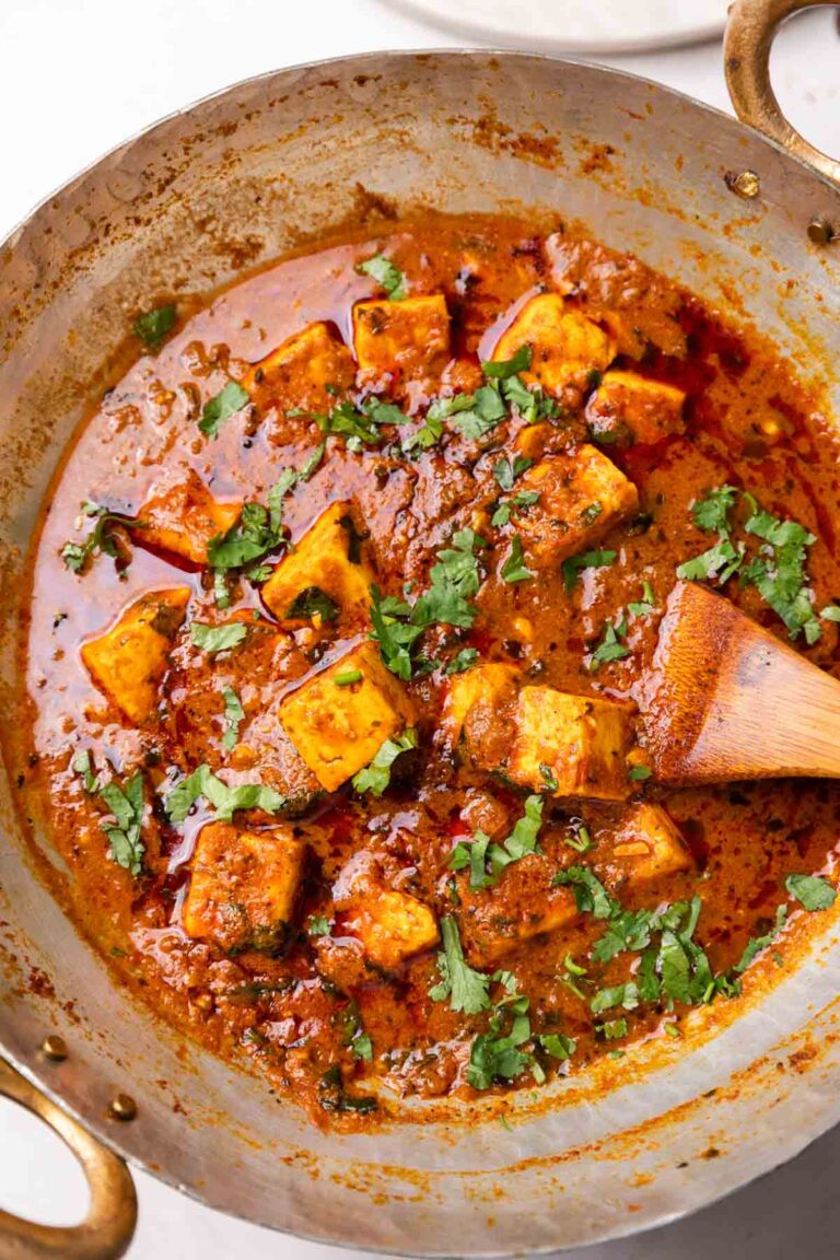 Dhaba style paneer masala in a kadhai with a wooden ladle