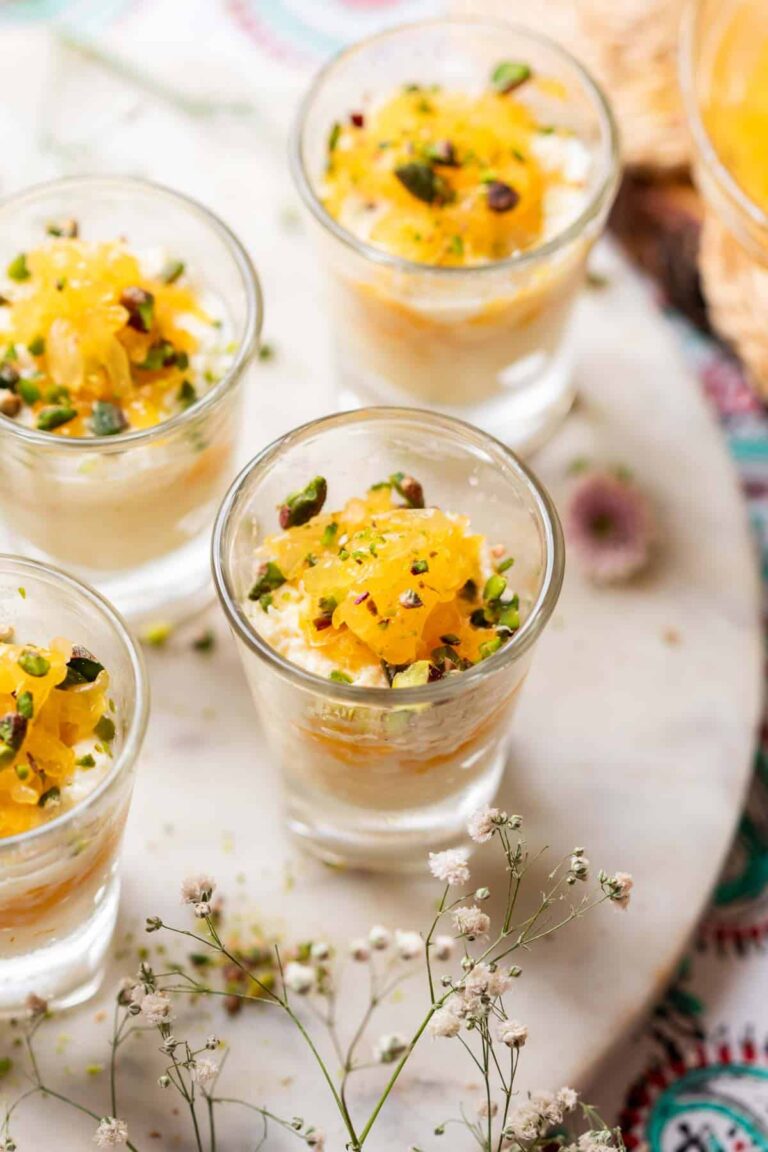 Orange kalakand served in shot glasses and topped with orange separates and chopped nuts