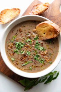 thick & wholesome horse gram soup garnished with birista and coriander, served with bread